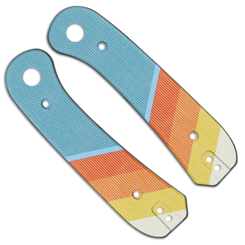 A pair of blue, orange, yellow, and off-white pocket knife scales on a white background.