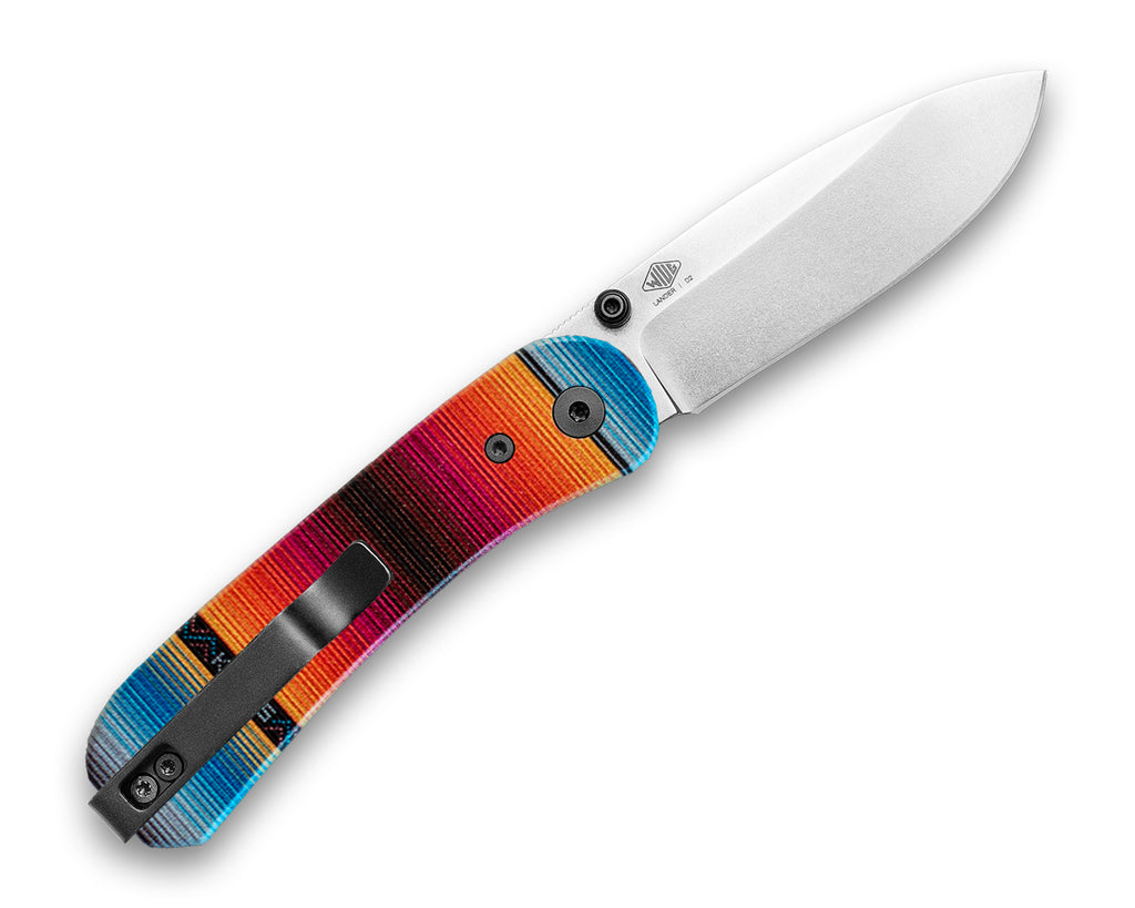 Knafs Lander 1 Pocket knife with Mexican Blanket G10 scales, opened back side with a D2 silver stone washed blade, lying flat on a white background at a 45 degree angle 